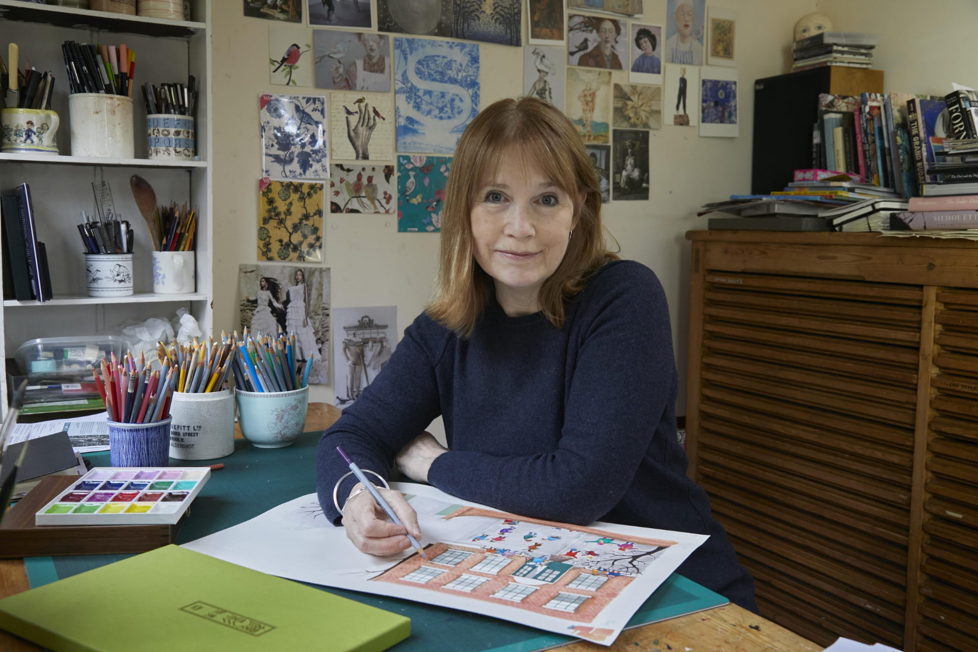 Jane Ray drawing at her desk in her studio